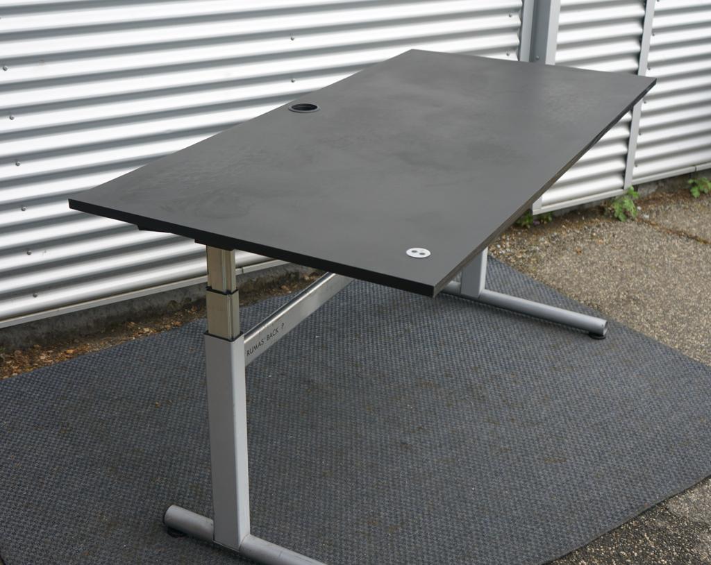 Rumas hæve-sænkebord 180x90 cm med sort linoleumsplade og elegant dansk design, set fra skrå vinkel.